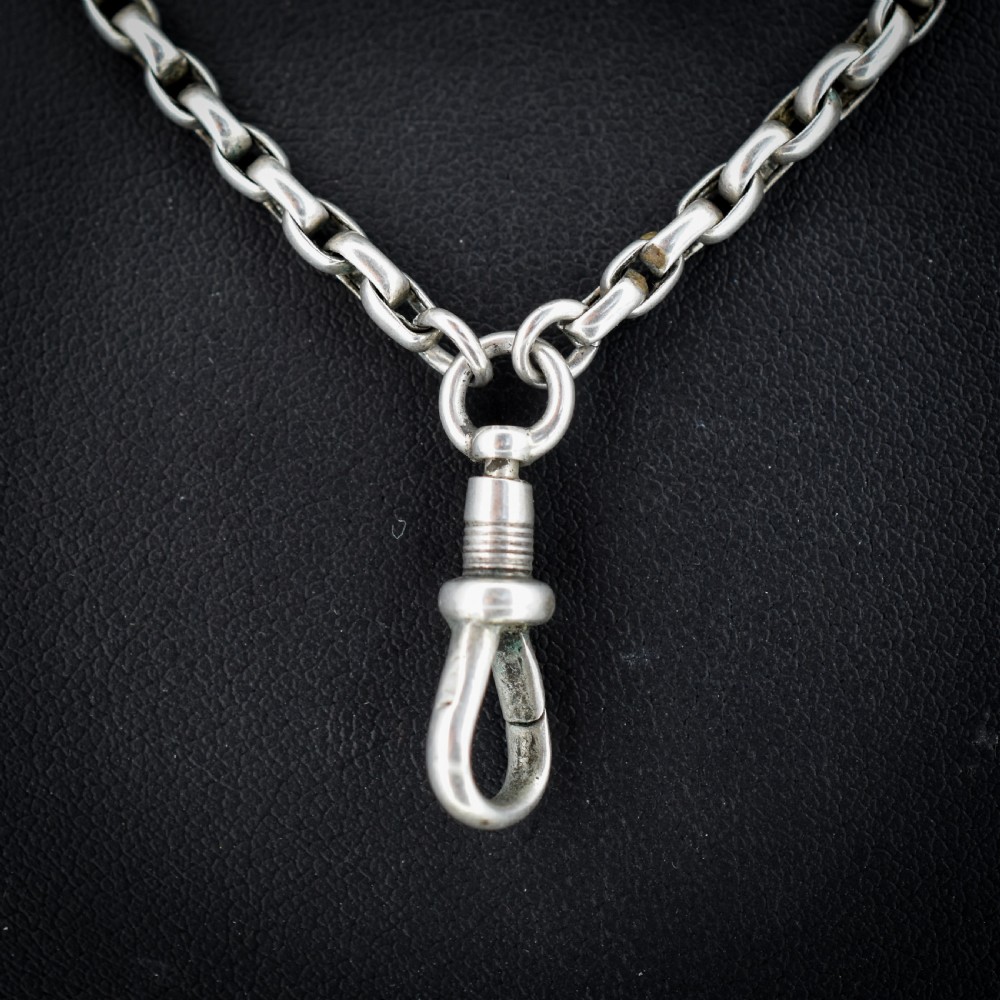An antique silver long guard chain featuring multiple loops of belcher links terminating in a swivel dog clip clasp. View III