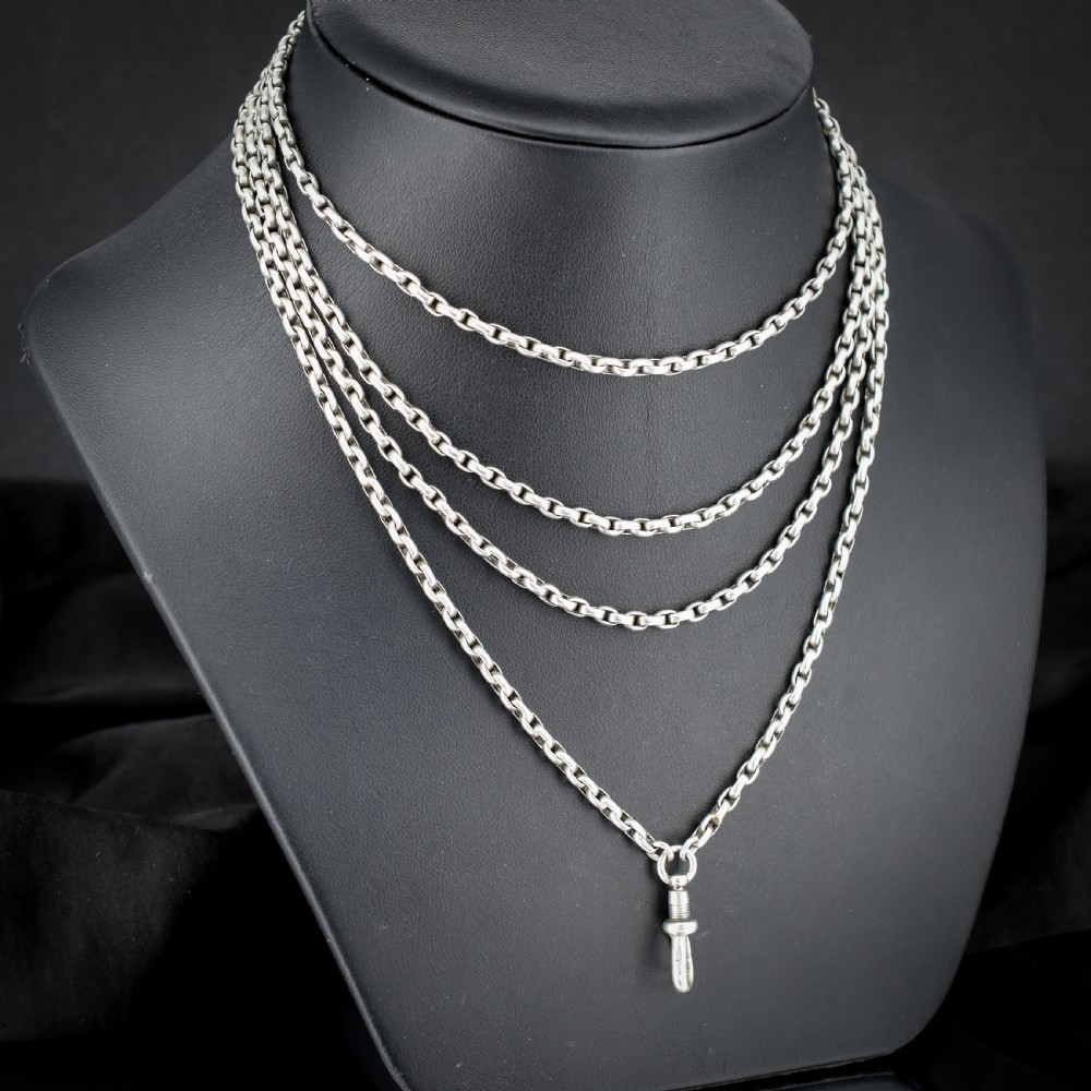 An antique silver long guard chain featuring multiple loops of belcher links terminating in a swivel dog clip clasp. View IV