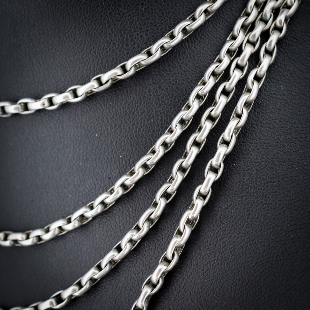 An antique silver long guard chain featuring multiple loops of belcher links terminating in a swivel dog clip clasp. View VI