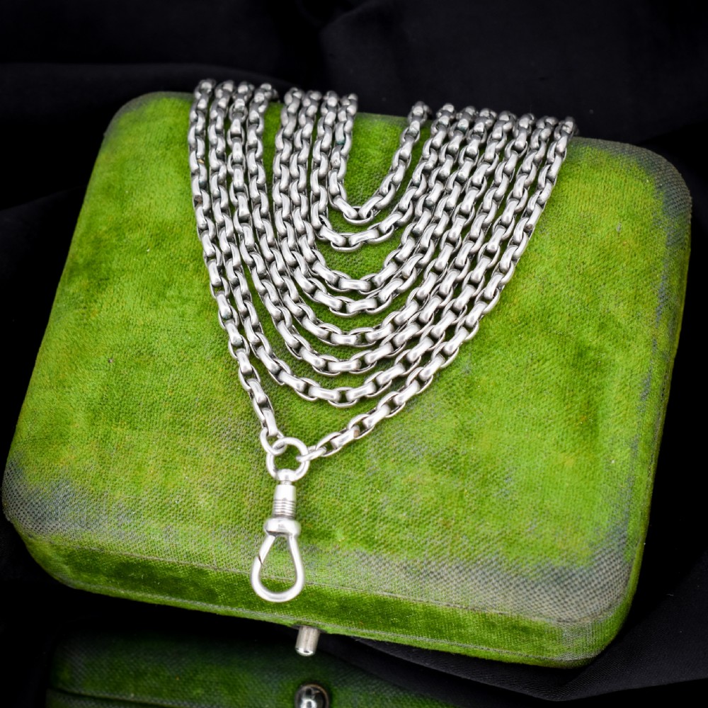 An antique silver long guard chain featuring multiple loops of belcher links terminating in a swivel dog clip clasp. View VII