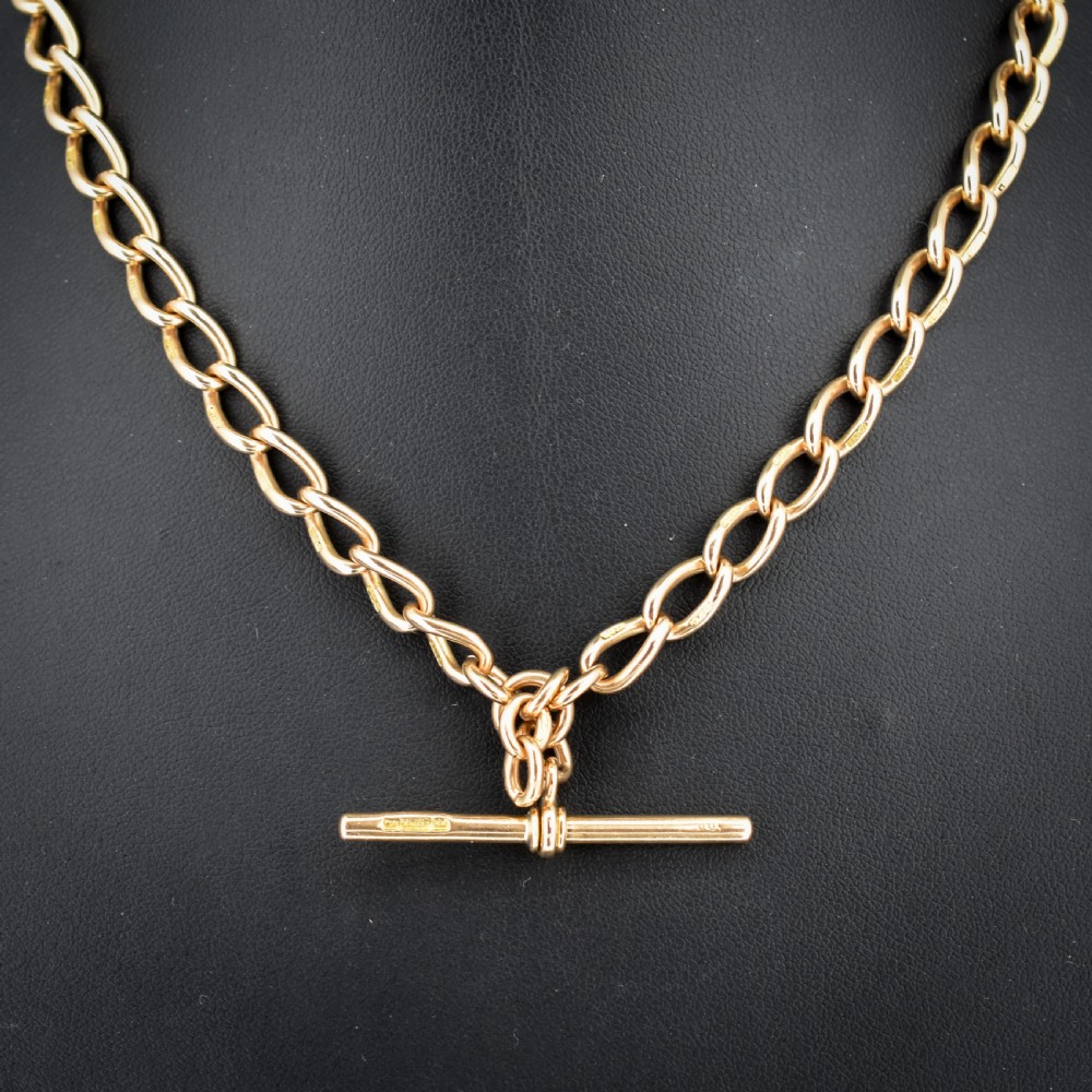 An antique 15ct yellow gold oval link Albert watch chain necklace featuring a suspended T-bar element.
