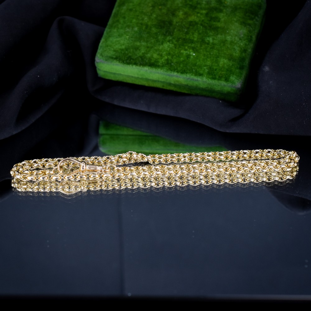 An antique 9ct yellow gold fancy link chain necklace with a dog clip clasp displayed on a green surface. View XI