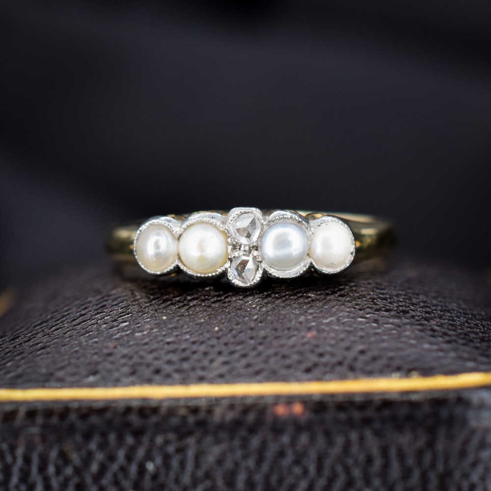 An antique 18ct yellow gold ring set with four light cream pearls and two central rose-cut diamonds arranged horizontally.