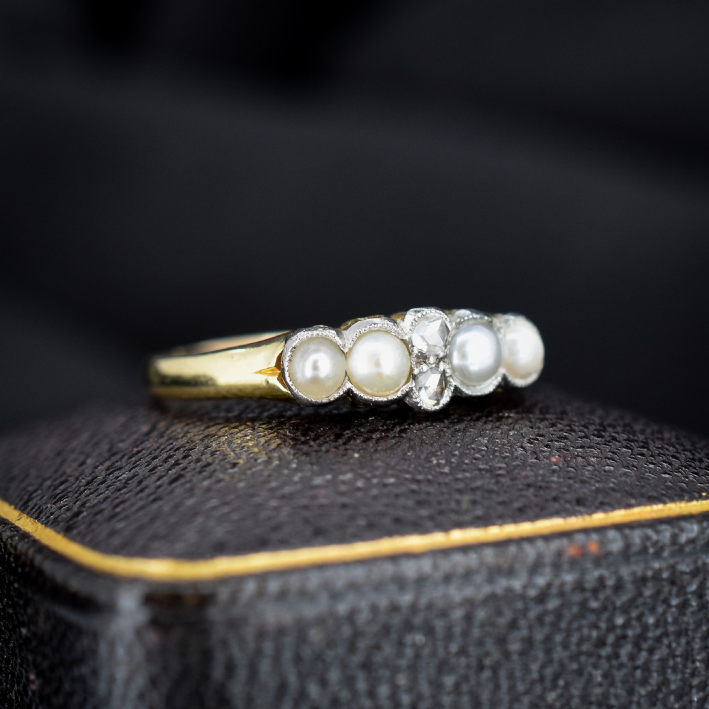 An antique 18ct yellow gold ring set with four light cream pearls and two central rose-cut diamonds arranged horizontally. View II