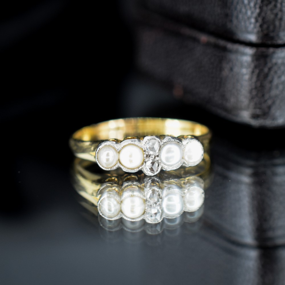An antique 18ct yellow gold ring set with four light cream pearls and two central rose-cut diamonds arranged horizontally. View III