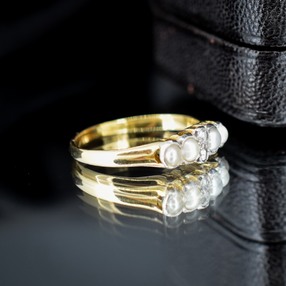 An antique 18ct yellow gold ring set with four light cream pearls and two central rose-cut diamonds arranged horizontally. View IV