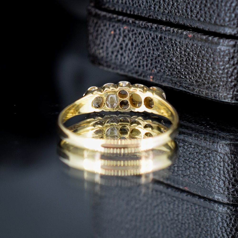 An antique 18ct yellow gold ring set with four light cream pearls and two central rose-cut diamonds arranged horizontally. View V