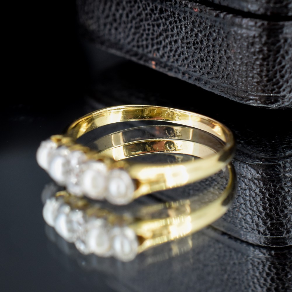An antique 18ct yellow gold ring set with four light cream pearls and two central rose-cut diamonds arranged horizontally. View VI