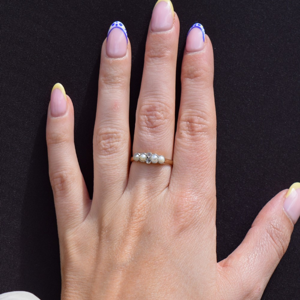 An antique 18ct yellow gold ring set with four light cream pearls and two central rose-cut diamonds arranged horizontally. View VII