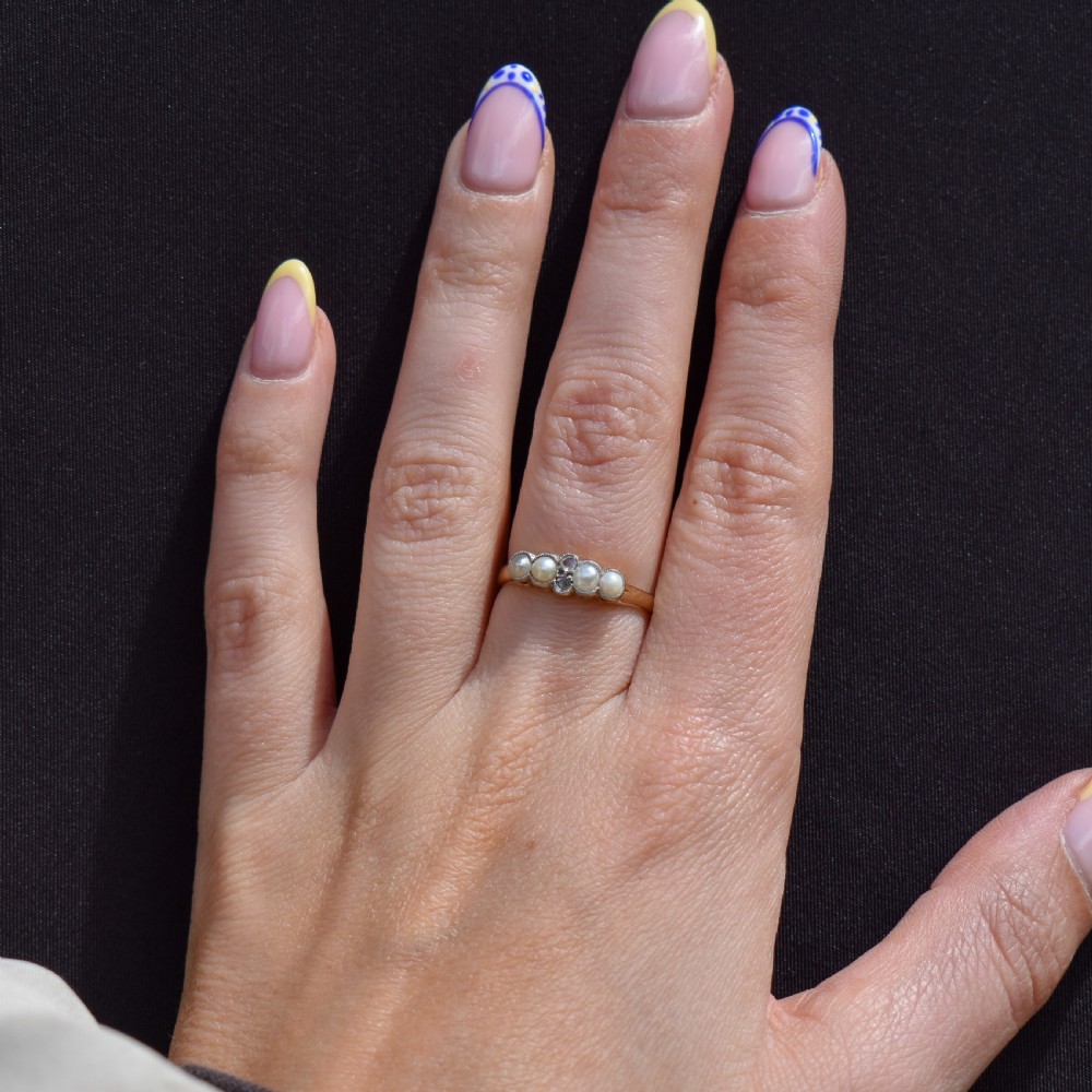 An antique 18ct yellow gold ring set with four light cream pearls and two central rose-cut diamonds arranged horizontally. View VIII