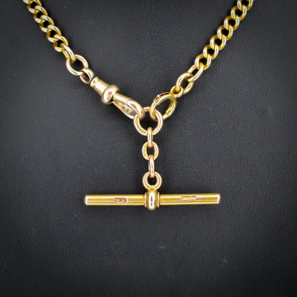 An antique 15ct yellow gold curb link Albert watch chain featuring a T-bar, dog clip, and bolt ring fastener, displayed inside a velvet fitted box. View III