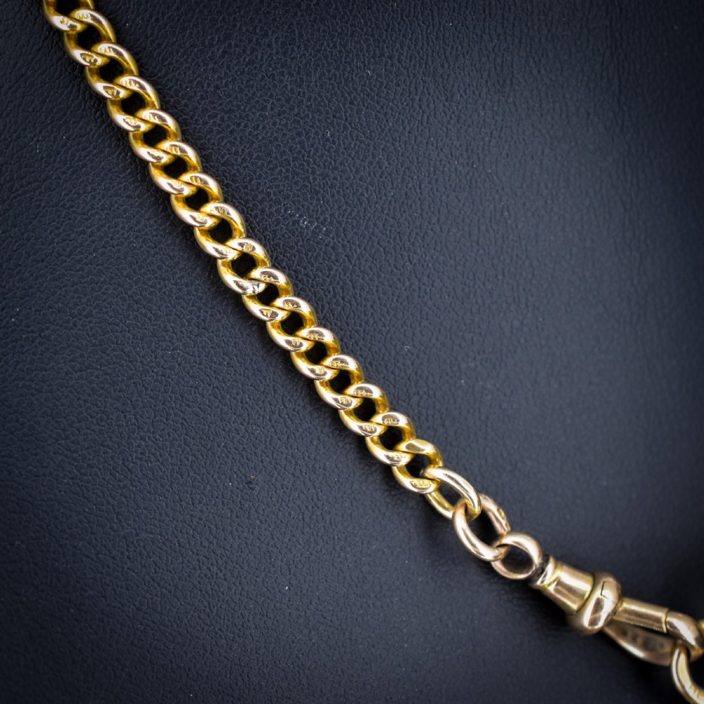 An antique 15ct yellow gold curb link Albert watch chain featuring a T-bar, dog clip, and bolt ring fastener, displayed inside a velvet fitted box. View IV