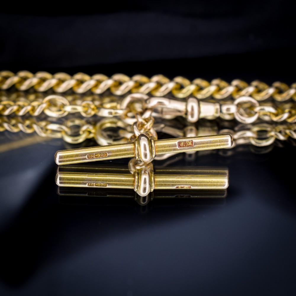 An antique 15ct yellow gold curb link Albert watch chain featuring a T-bar, dog clip, and bolt ring fastener, displayed inside a velvet fitted box. View VII