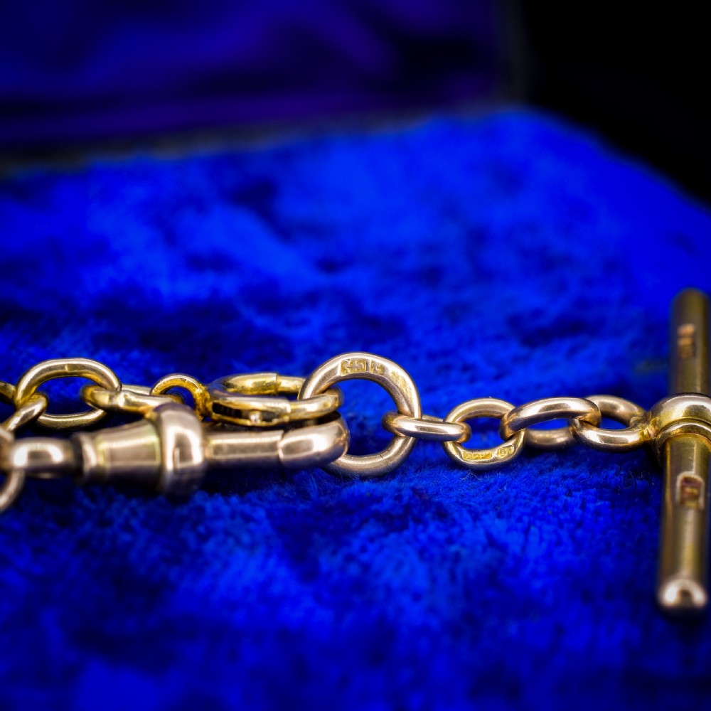 An antique 15ct yellow gold curb link Albert watch chain featuring a T-bar, dog clip, and bolt ring fastener, displayed inside a velvet fitted box. View VIII