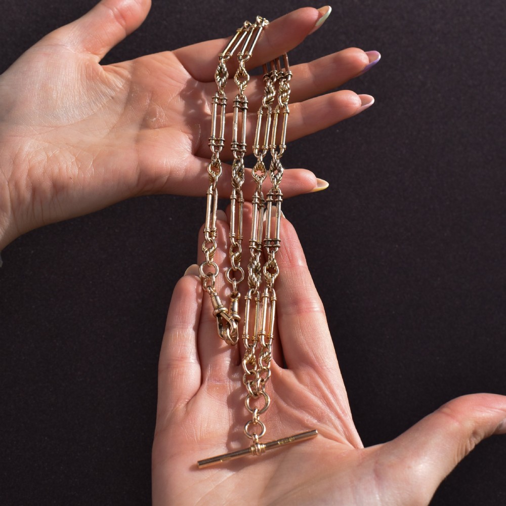 An antique 15ct yellow gold curb link Albert watch chain featuring a T-bar, dog clip, and bolt ring fastener, displayed inside a velvet fitted box. View XII