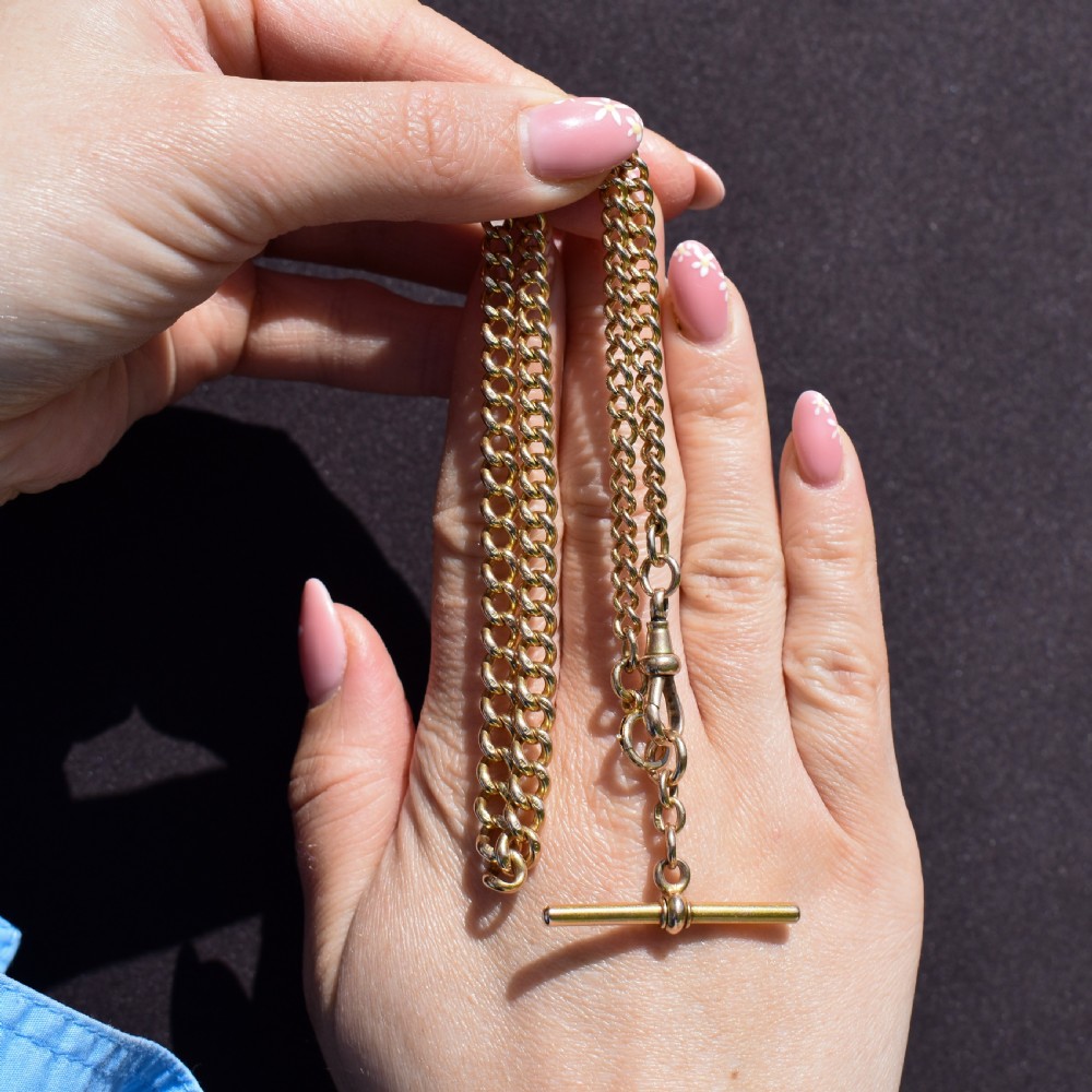 An antique 15ct yellow gold curb link Albert watch chain featuring a T-bar, dog clip, and bolt ring fastener, displayed inside a velvet fitted box. View XIII
