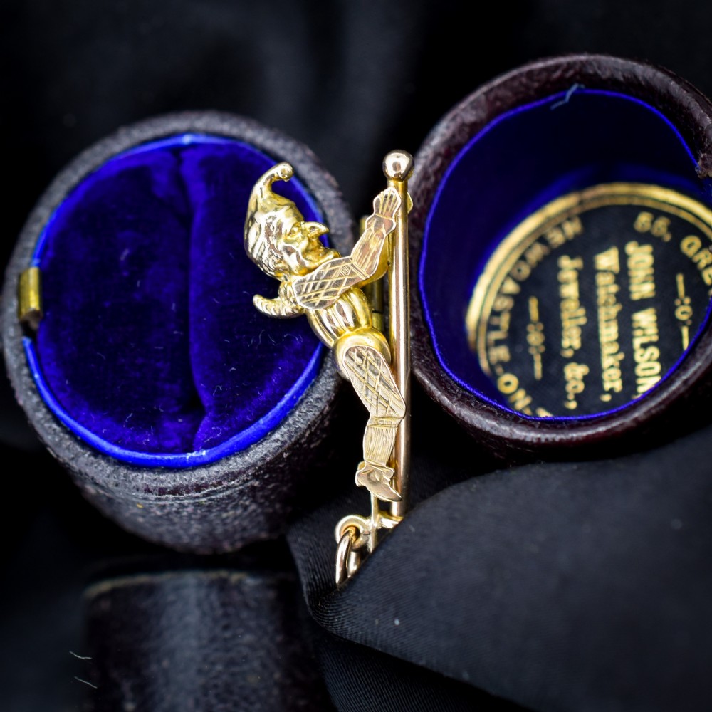 An antique 9ct yellow gold charm depicting the character Mr Punch sliding down a central vertical pin. View III