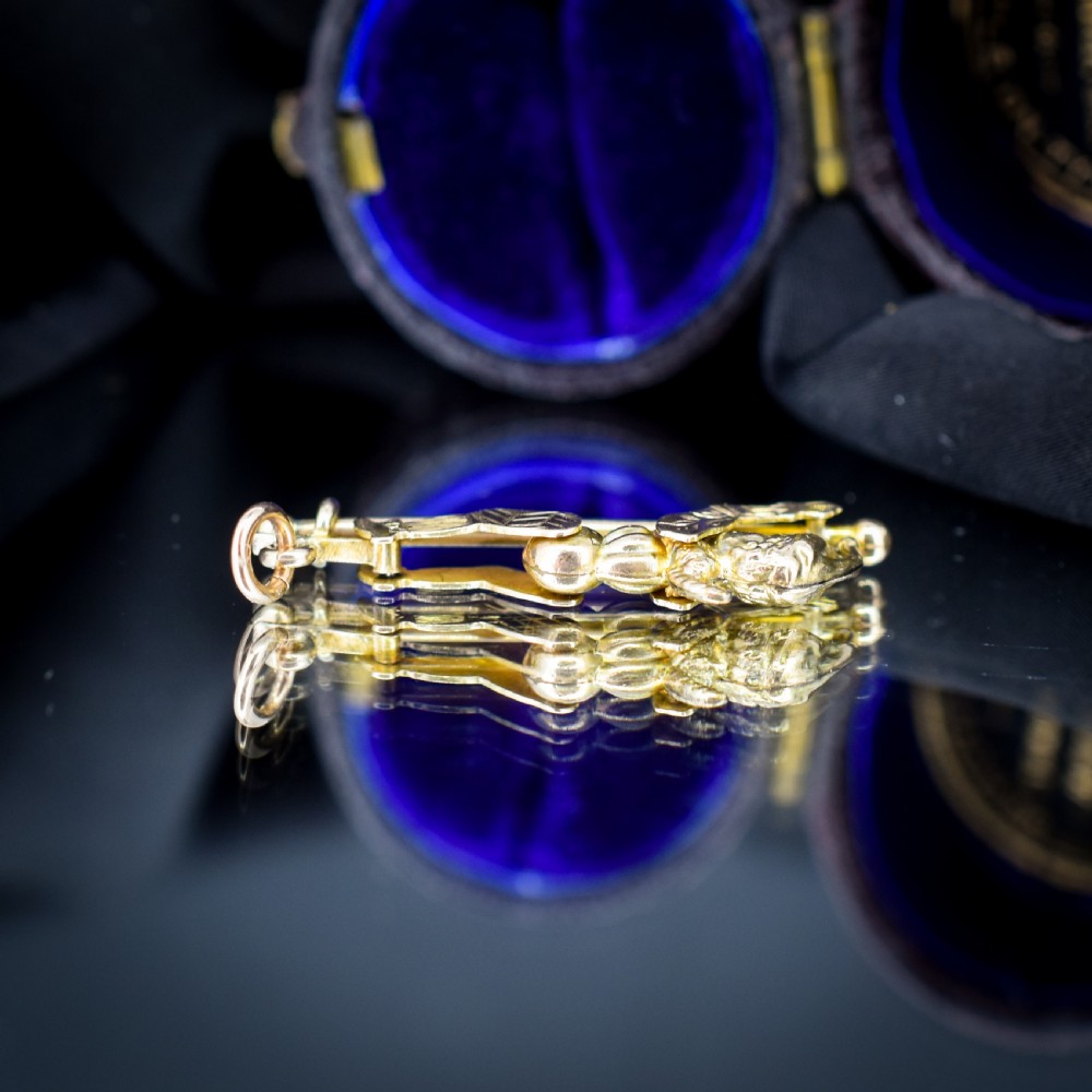 An antique 9ct yellow gold charm depicting the character Mr Punch sliding down a central vertical pin. View VII
