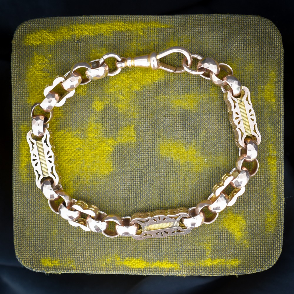 An antique 9ct gold chain bracelet featuring alternating star-and-bar decorative links and faceted round links with a swivel clasp.