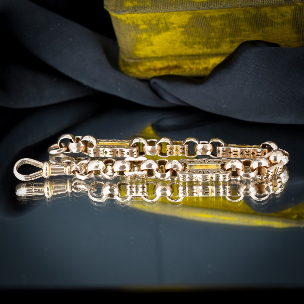 An antique 9ct gold chain bracelet featuring alternating star-and-bar decorative links and faceted round links with a swivel clasp. View II