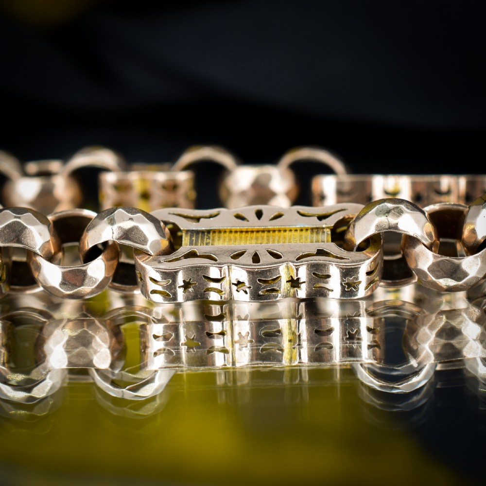 An antique 9ct gold chain bracelet featuring alternating star-and-bar decorative links and faceted round links with a swivel clasp. View IV