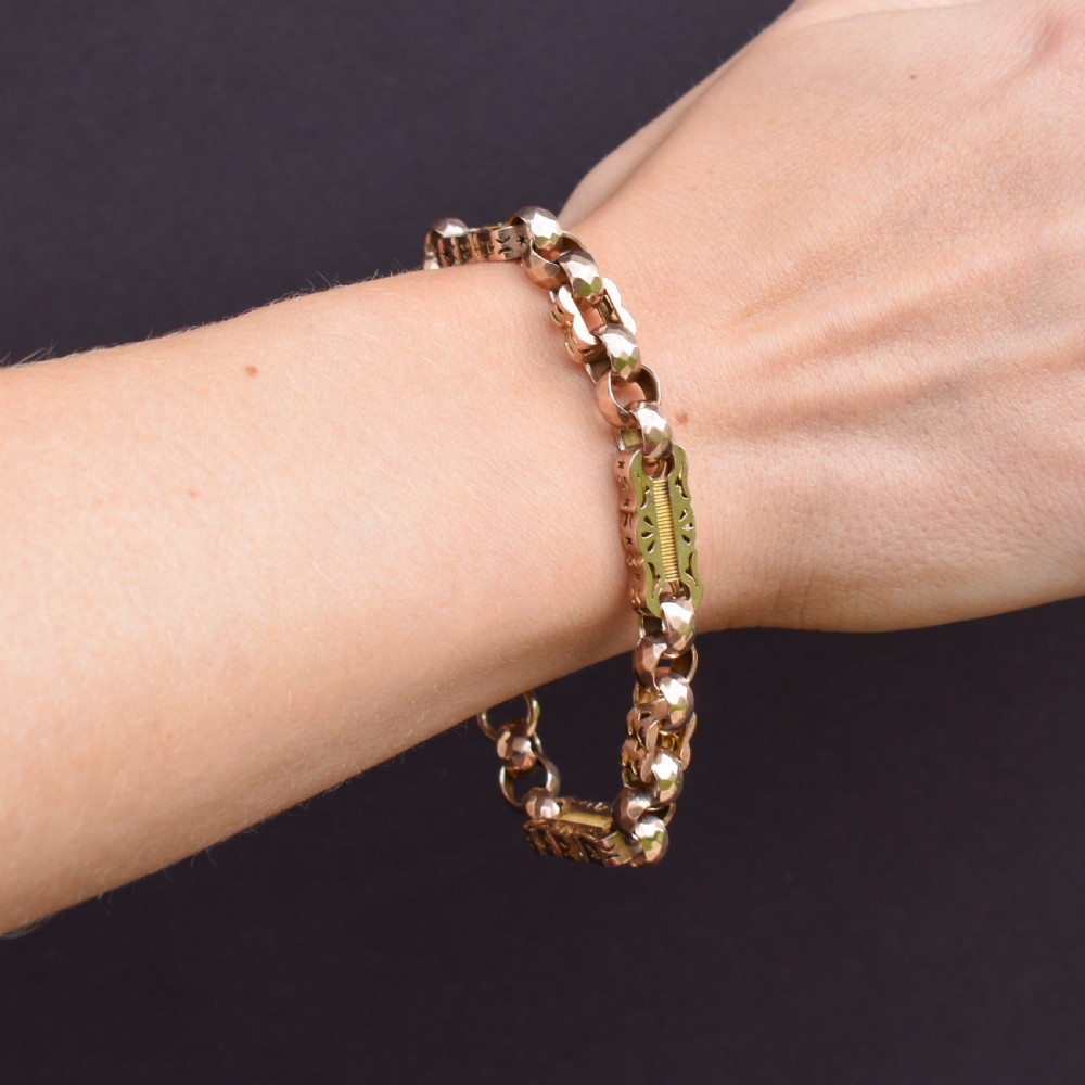 An antique 9ct gold chain bracelet featuring alternating star-and-bar decorative links and faceted round links with a swivel clasp. View XI