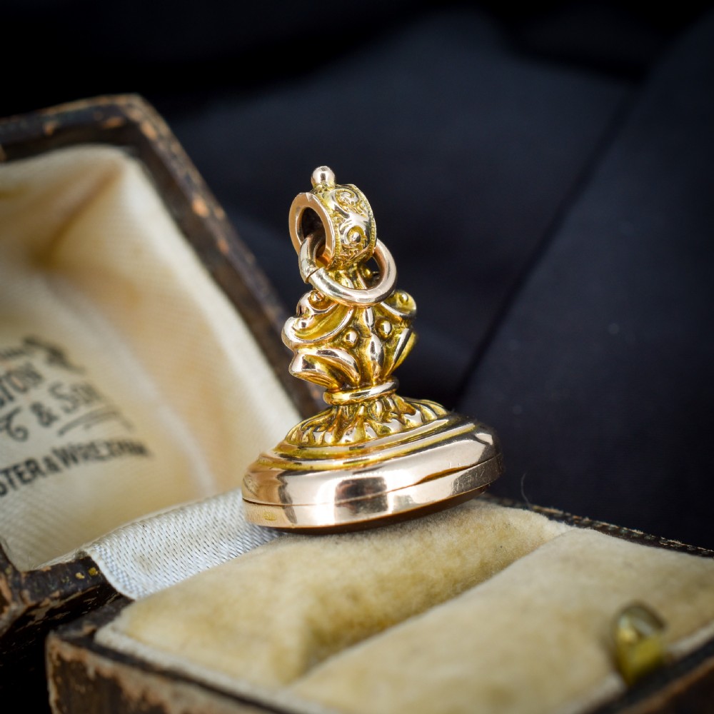An Edwardian 9ct gold fob featuring chased scrollwork, a top suspension ring, and a carnelian seal base. View III