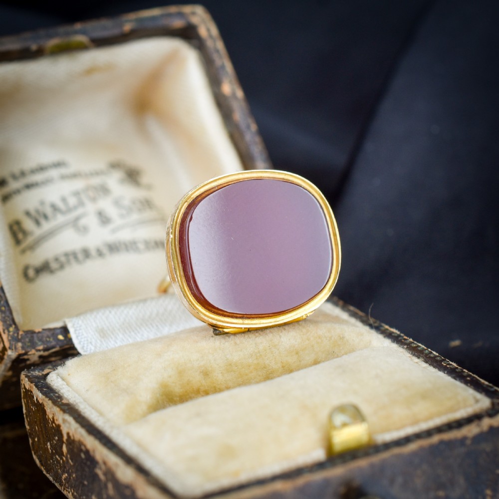 An Edwardian 9ct gold fob featuring chased scrollwork, a top suspension ring, and a carnelian seal base. View IV