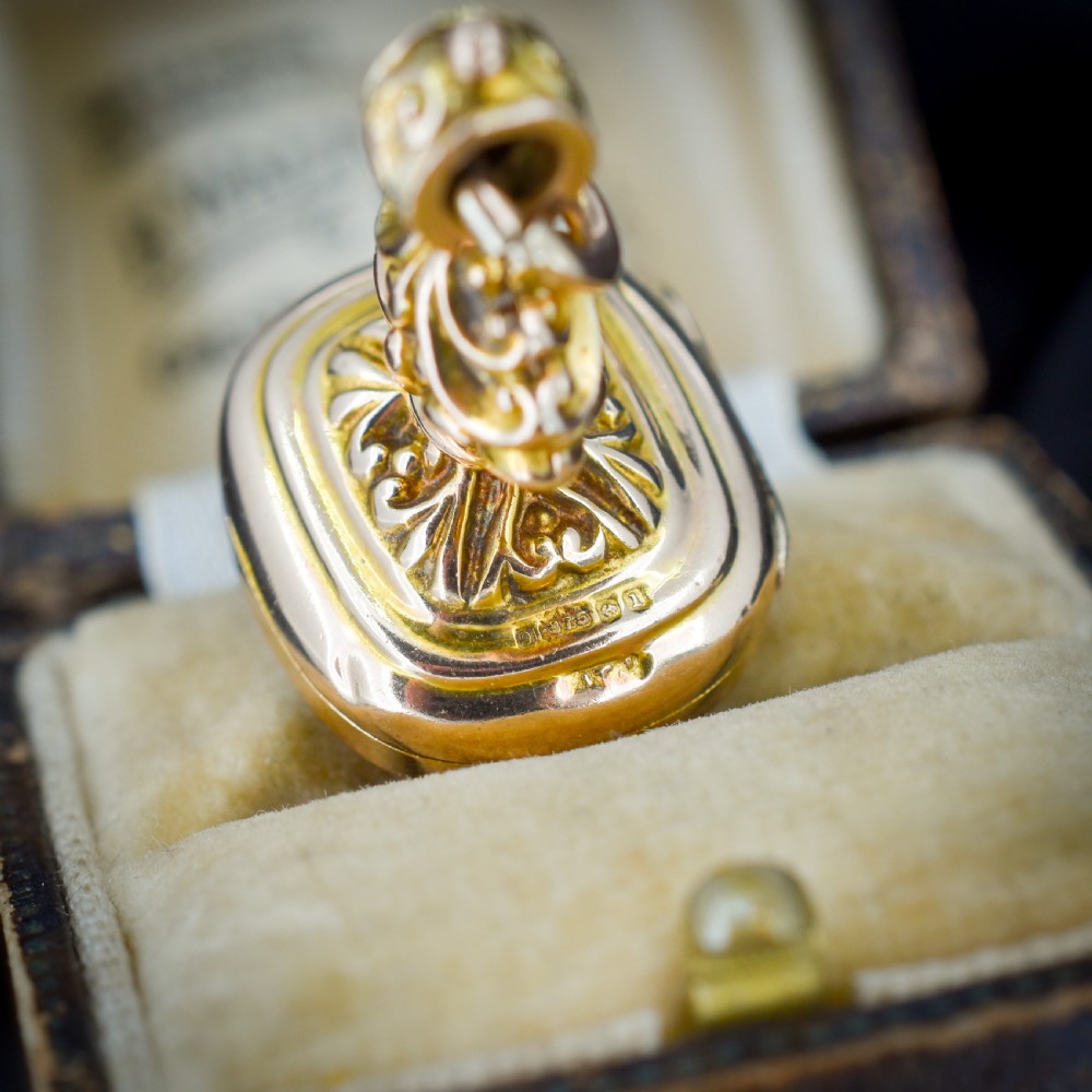 An Edwardian 9ct gold fob featuring chased scrollwork, a top suspension ring, and a carnelian seal base. View V