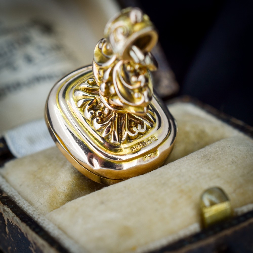 An Edwardian 9ct gold fob featuring chased scrollwork, a top suspension ring, and a carnelian seal base. View VII