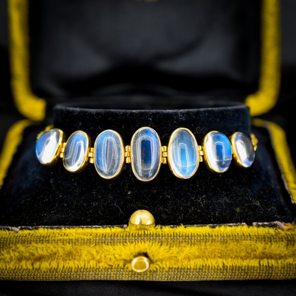 An antique 18ct gold link bracelet set with seven graduating oval moonstone cabochons.