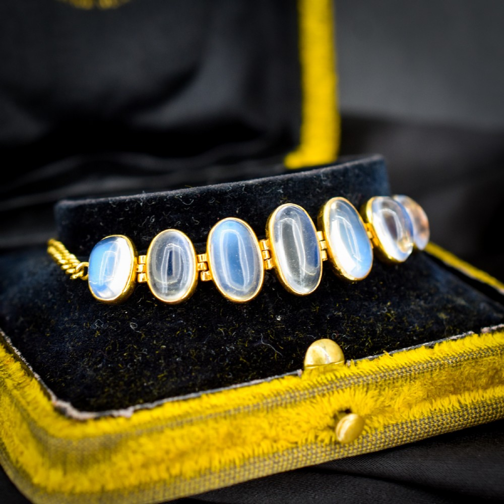 An antique 18ct gold link bracelet set with seven graduating oval moonstone cabochons. View II
