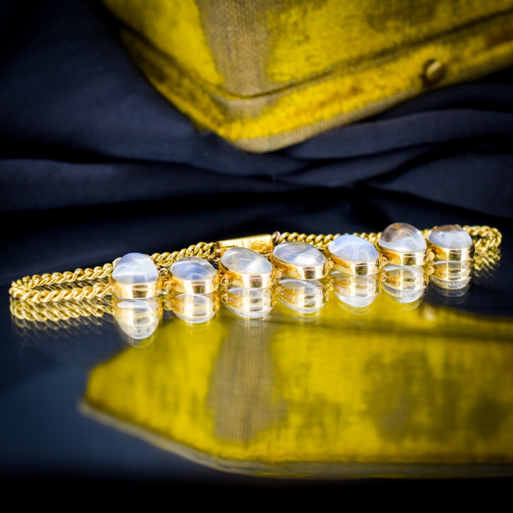 An antique 18ct gold link bracelet set with seven graduating oval moonstone cabochons. View III