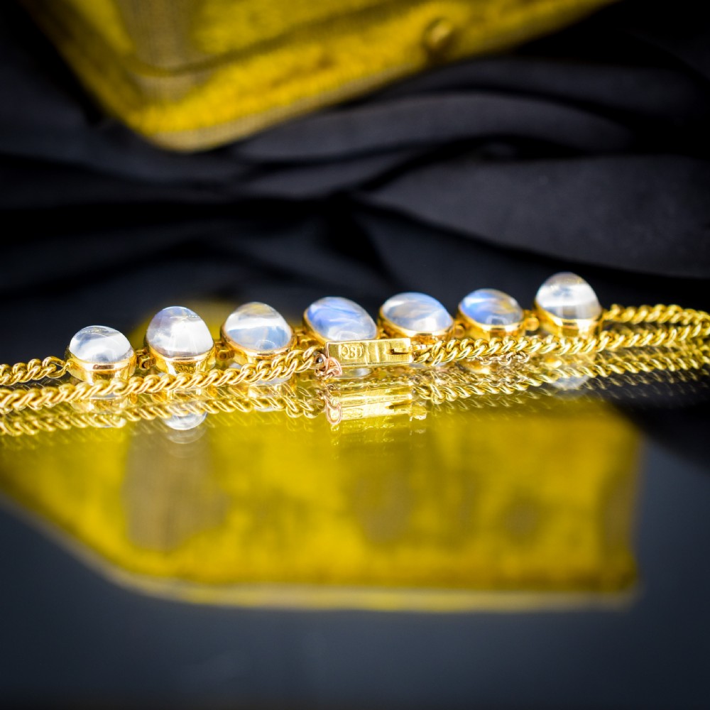 An antique 18ct gold link bracelet set with seven graduating oval moonstone cabochons. View IV