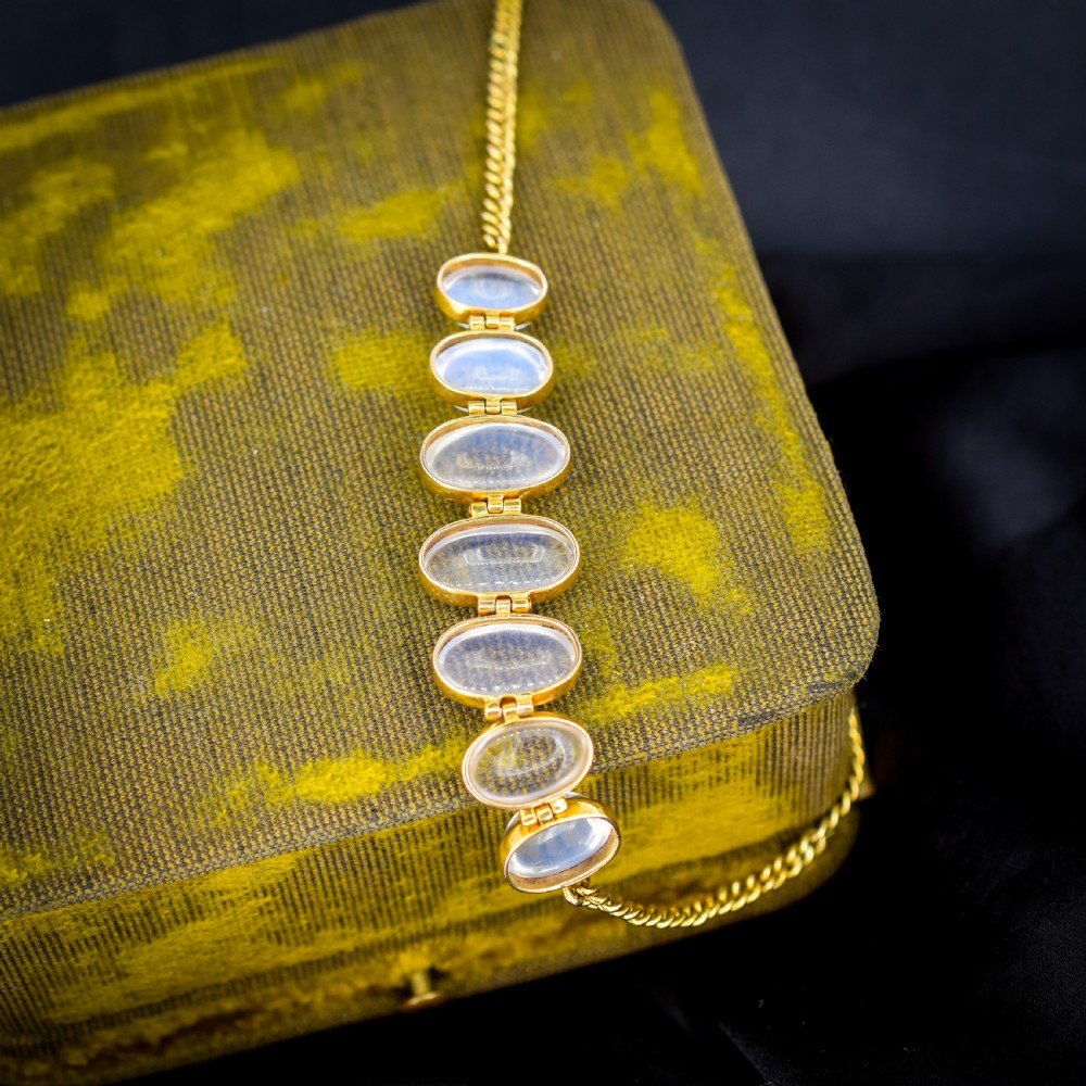 An antique 18ct gold link bracelet set with seven graduating oval moonstone cabochons. View V