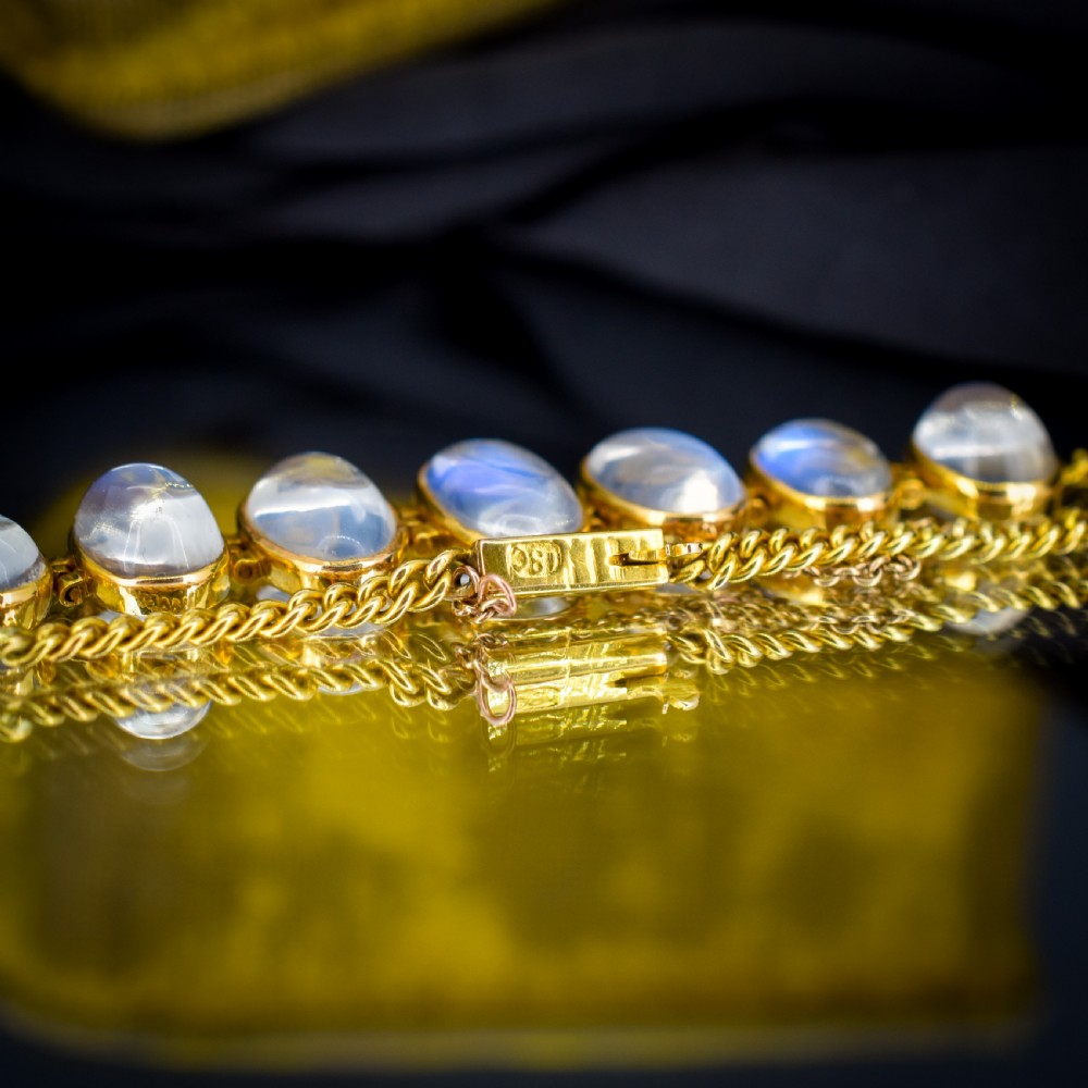 An antique 18ct gold link bracelet set with seven graduating oval moonstone cabochons. View VI