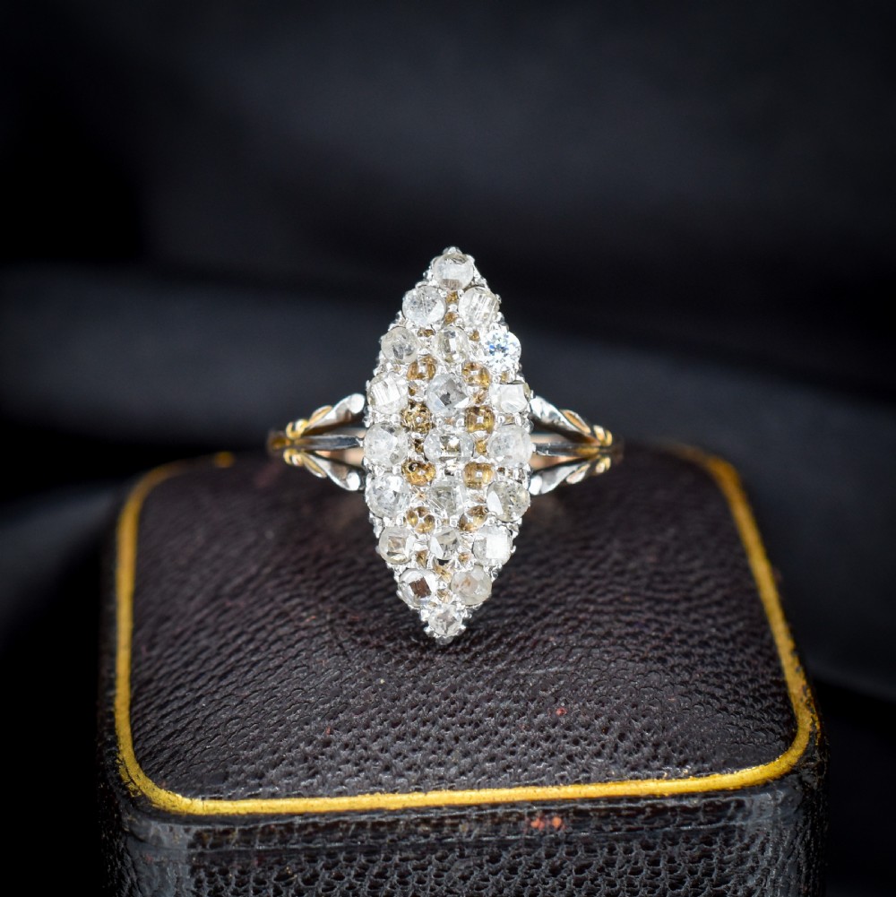 A Victorian 18ct gold navette ring featuring a cluster of multiple old-cut diamonds set in silver-topped shoulders and head.