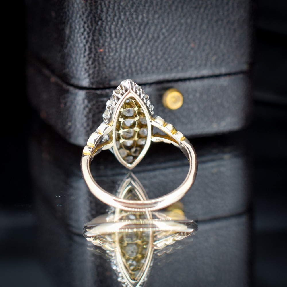 A Victorian 18ct gold navette ring featuring a cluster of multiple old-cut diamonds set in silver-topped shoulders and head. View IV