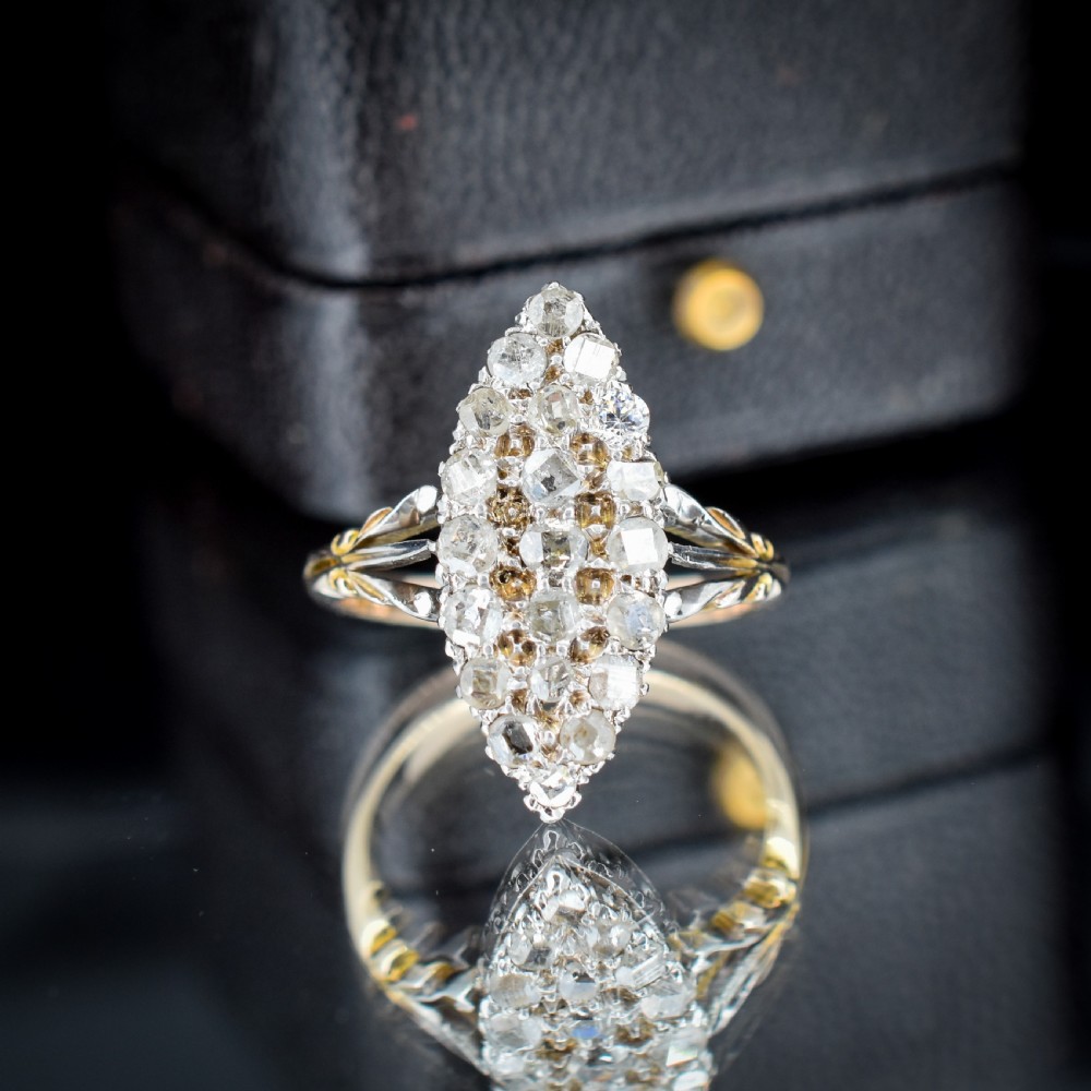 A Victorian 18ct gold navette ring featuring a cluster of multiple old-cut diamonds set in silver-topped shoulders and head. View V