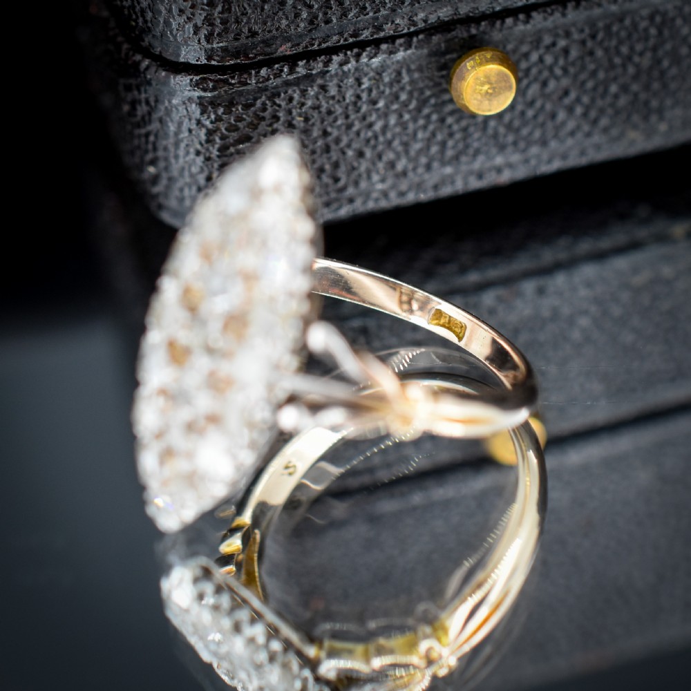 A Victorian 18ct gold navette ring featuring a cluster of multiple old-cut diamonds set in silver-topped shoulders and head. View VI