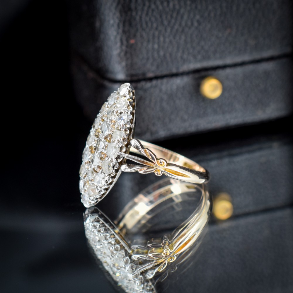 A Victorian 18ct gold navette ring featuring a cluster of multiple old-cut diamonds set in silver-topped shoulders and head. View VII