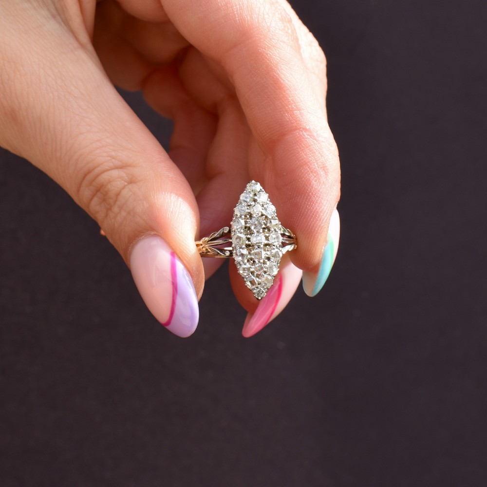 A Victorian 18ct gold navette ring featuring a cluster of multiple old-cut diamonds set in silver-topped shoulders and head. View IX