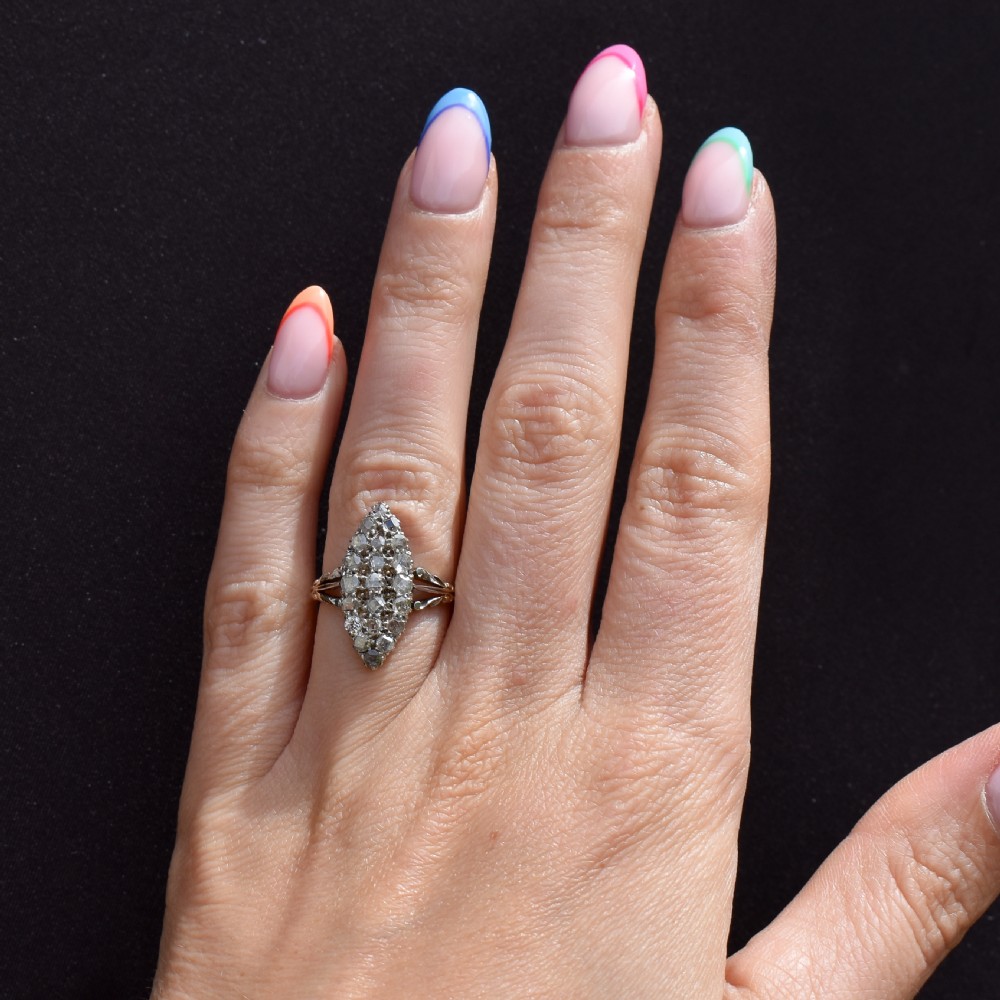 A Victorian 18ct gold navette ring featuring a cluster of multiple old-cut diamonds set in silver-topped shoulders and head. View X