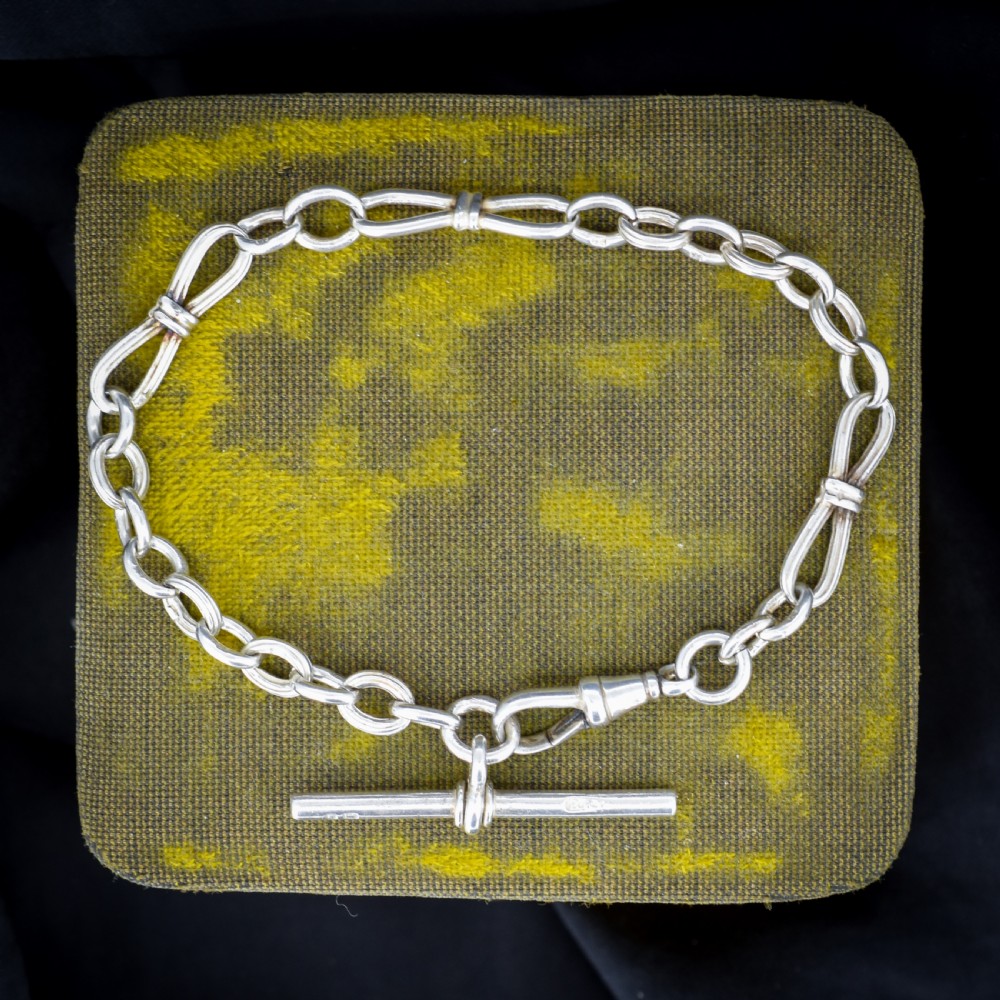 An antique sterling silver fancy link chain bracelet featuring a dog clip fastener and a suspended T-bar drop. View II