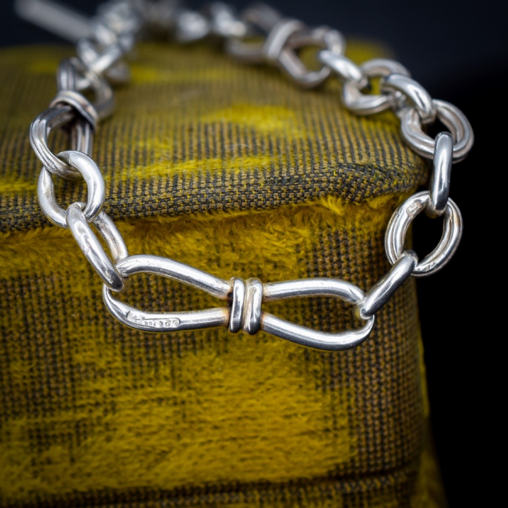 An antique sterling silver fancy link chain bracelet featuring a dog clip fastener and a suspended T-bar drop. View IV