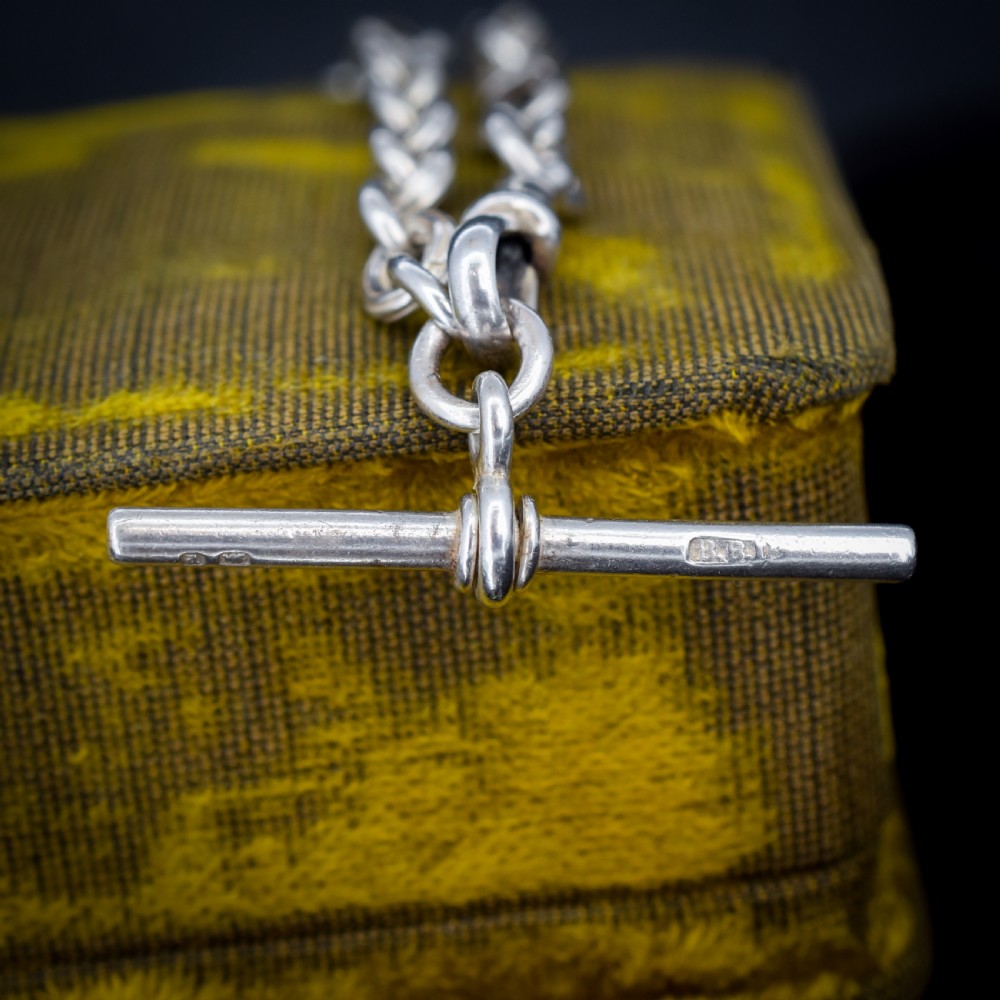 An antique sterling silver fancy link chain bracelet featuring a dog clip fastener and a suspended T-bar drop. View V