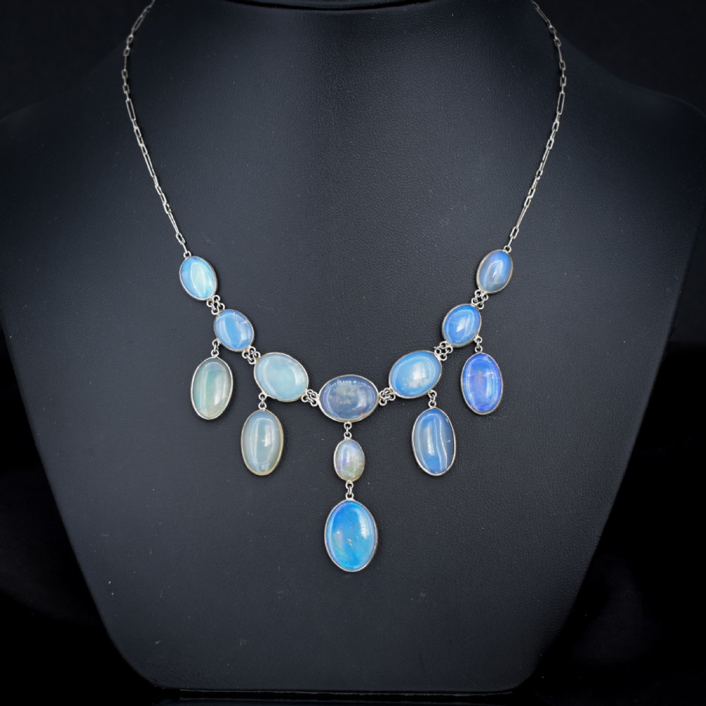 An Edwardian silver festoon necklace featuring graduated oval cabochon opals arranged in hanging fringe drops. View II