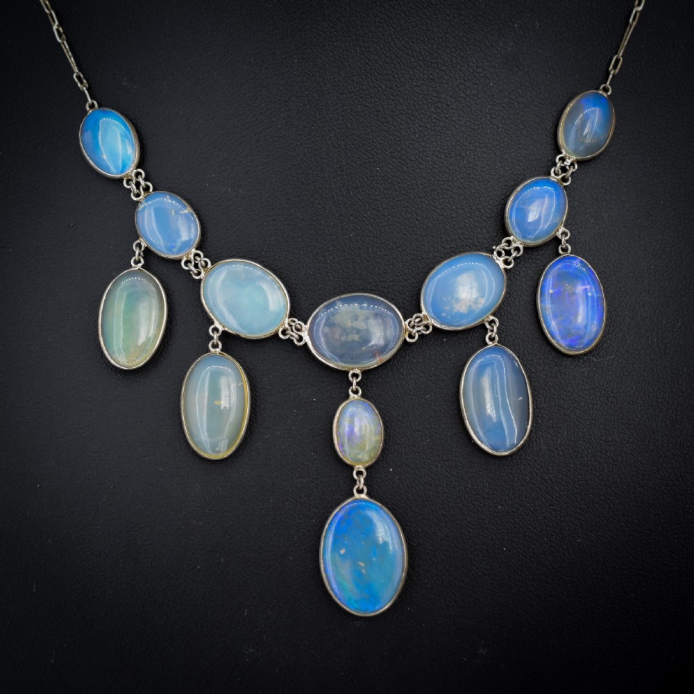 An Edwardian silver festoon necklace featuring graduated oval cabochon opals arranged in hanging fringe drops. View III