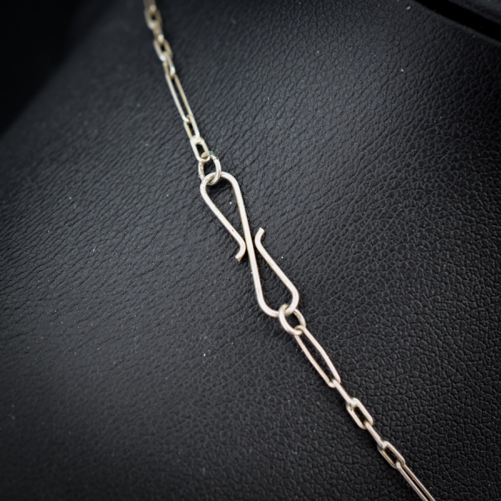 An Edwardian silver festoon necklace featuring graduated oval cabochon opals arranged in hanging fringe drops. View V