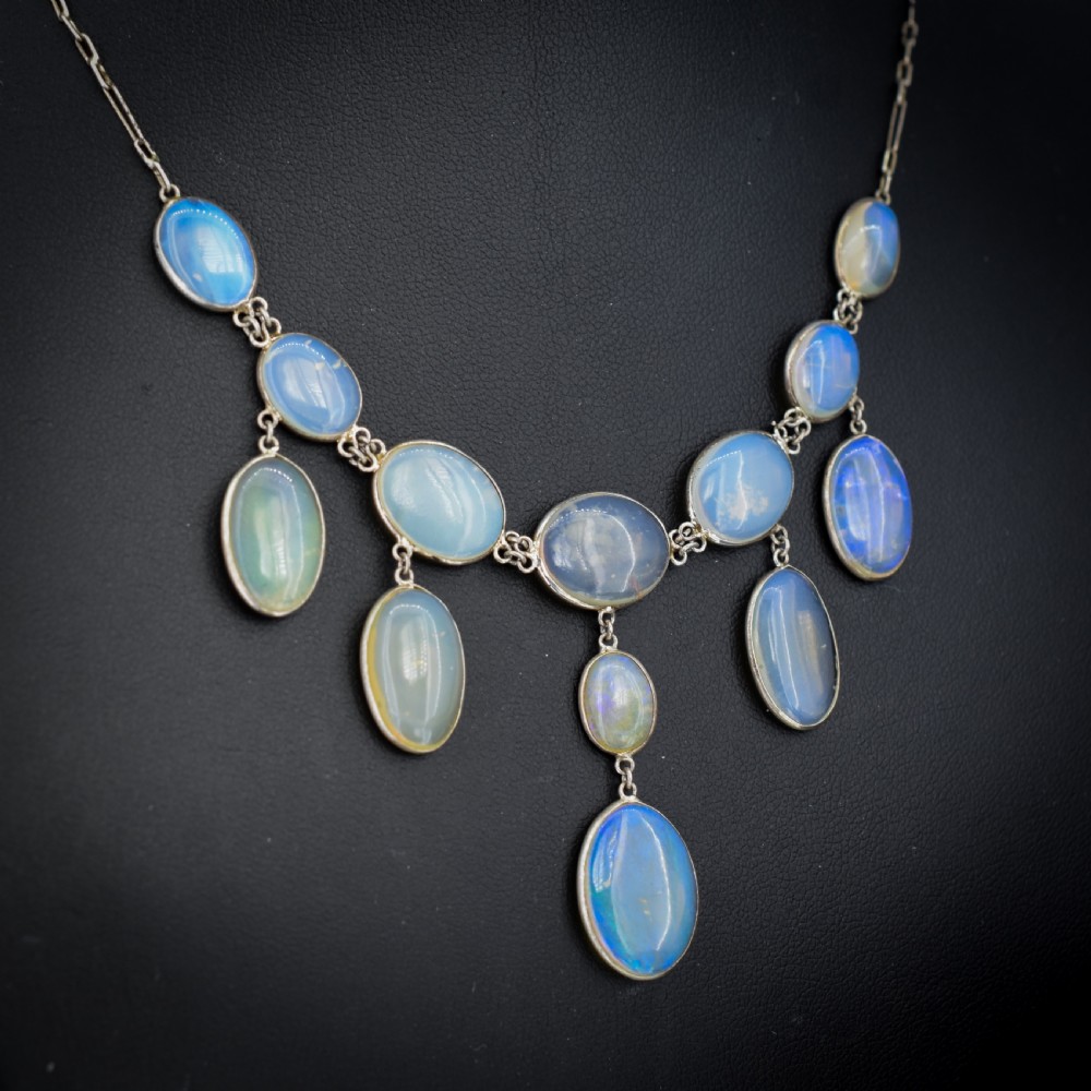An Edwardian silver festoon necklace featuring graduated oval cabochon opals arranged in hanging fringe drops. View VI